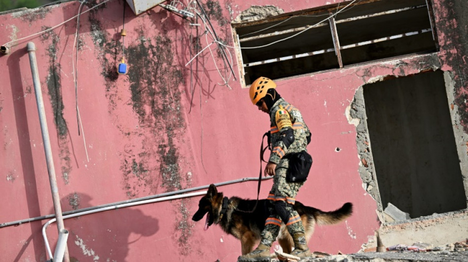 A painful wait by a pile of rubble in quake-hit Venezuela